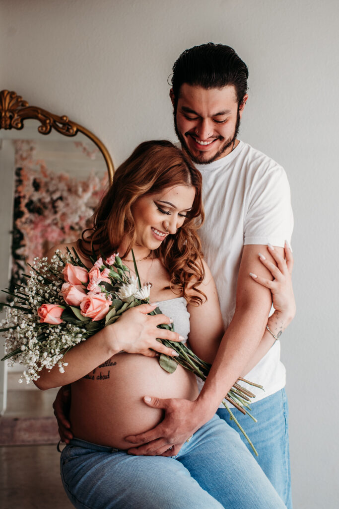 Lifestyle maternity photography in studio. Bare belly pregnancy photo.