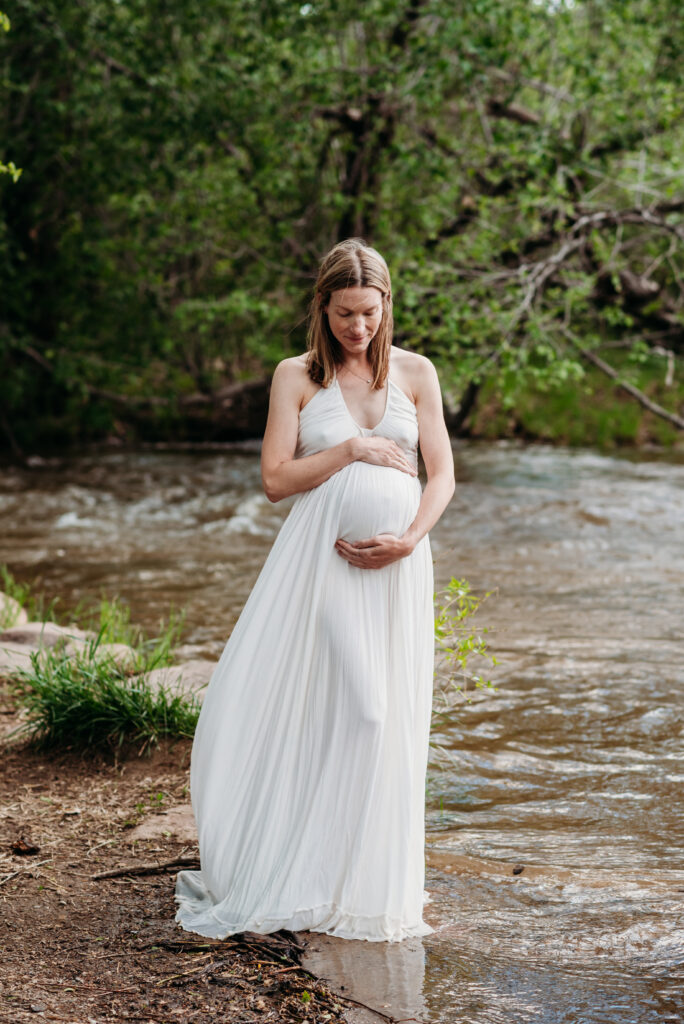 White maternity dress photography. Pregnancy photos in creek in Boulder Colorado.