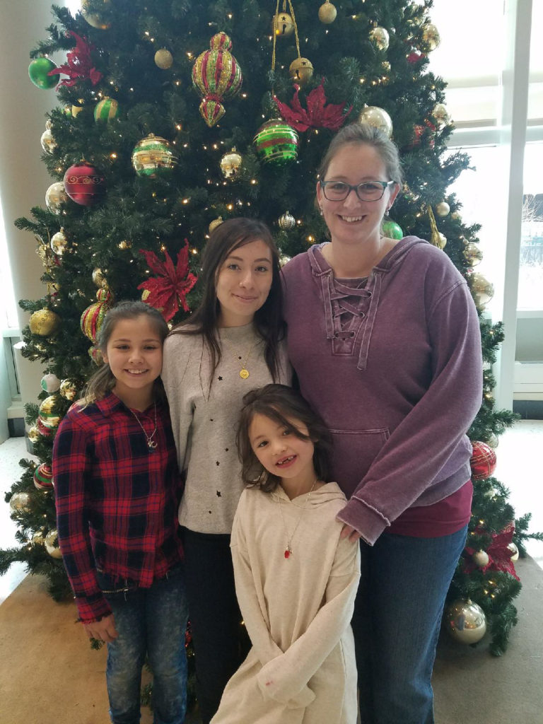 The pregnant author with her three daughters in front of a Christmas tree in the lobby of University of Colorado Anschutz in Aurora Colorado