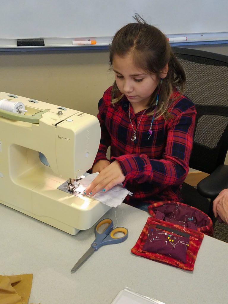 The author's daughter learning to sew with a sewing machine at the hospital while the author was admitted for PPROM