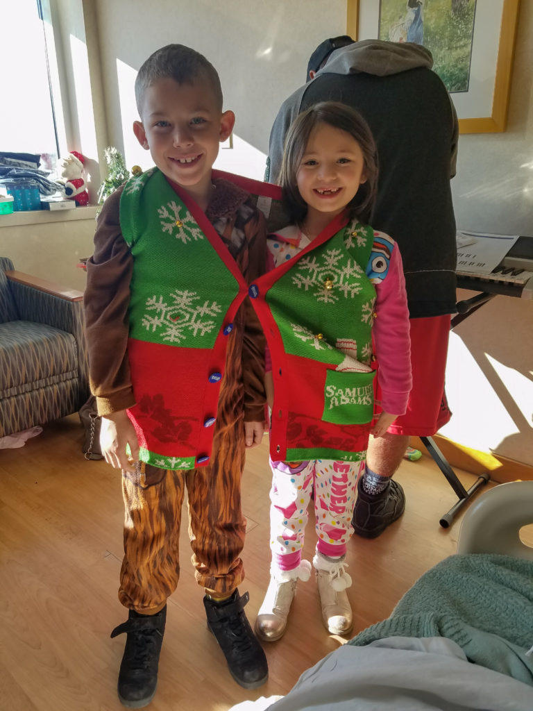 The author's daughter and nephew buttoned up into one sweater vest together during Christmas in the hospital.