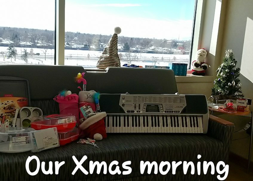 Christmas gifts displayed on the couch in a hospital room. It reads "our xmas morning."