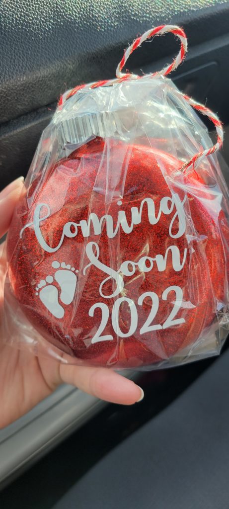 Red Christmas ornament pregnancy announcement "Coming Soon 2022"