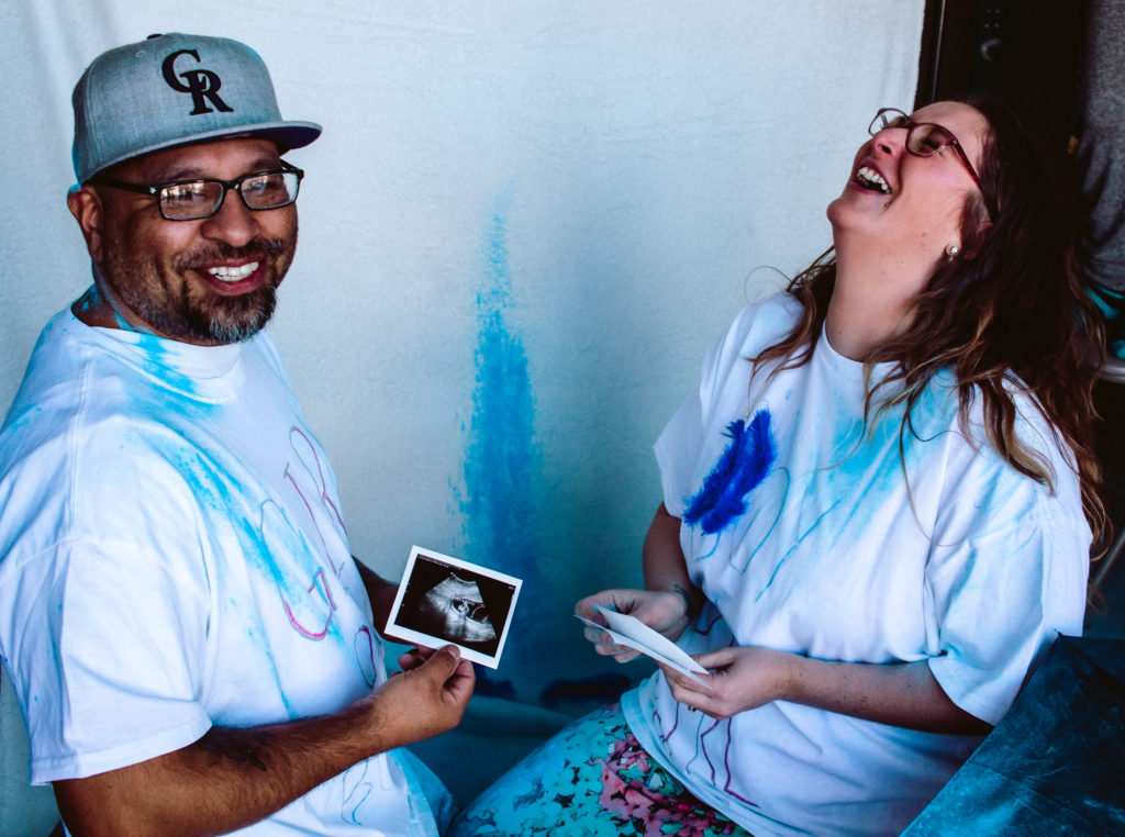 amyquinnphotographyandbirth.com
dad holding gender ultrasound and smiling It's a boy gender reveal
