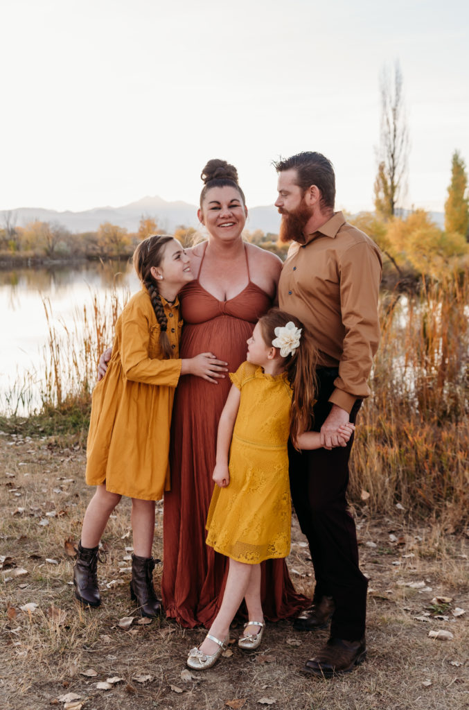 Family maternity photo mountain background orange and yellow dresses dad in brown
