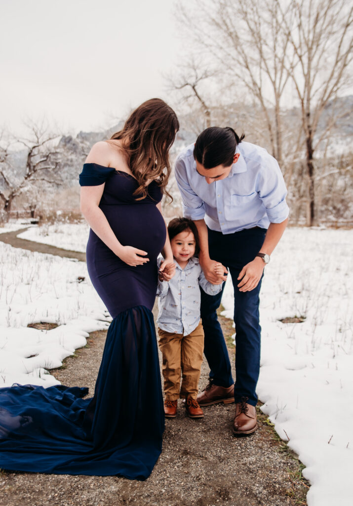 navy blue maternity dress in snow family maternity photo with toddler Longmont Colorado maternity photography