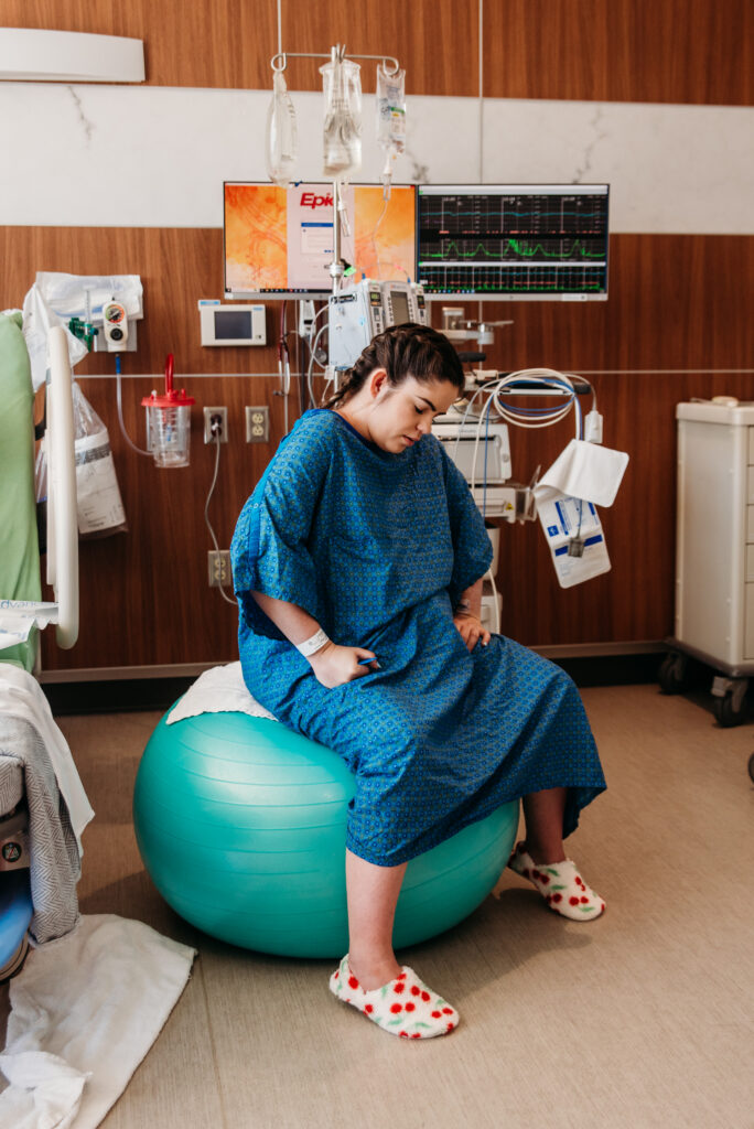 Laboring on a yoga ball in the hospital with Longmont Colorado birth photographer