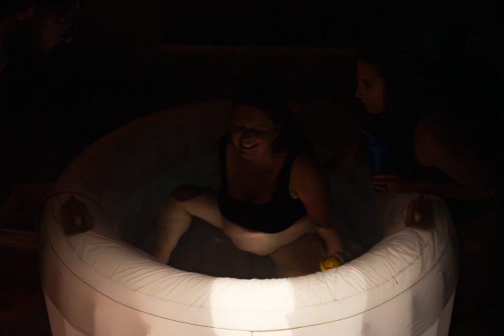 A very dark labor scene of mom in a birth tub.