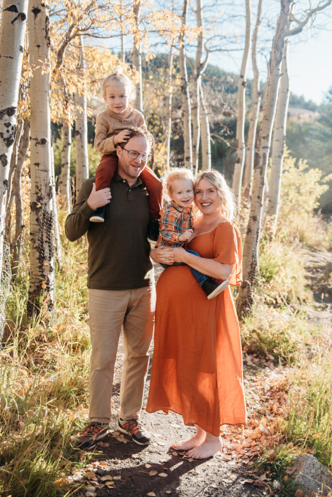 Orange dress family maternity photo with mom dad and two sons in Nederland Colorado