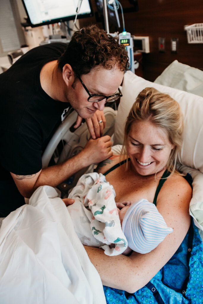 Mom and dad admiring their just birthed baby girl in longmont colorado. Surprise gender birth story.