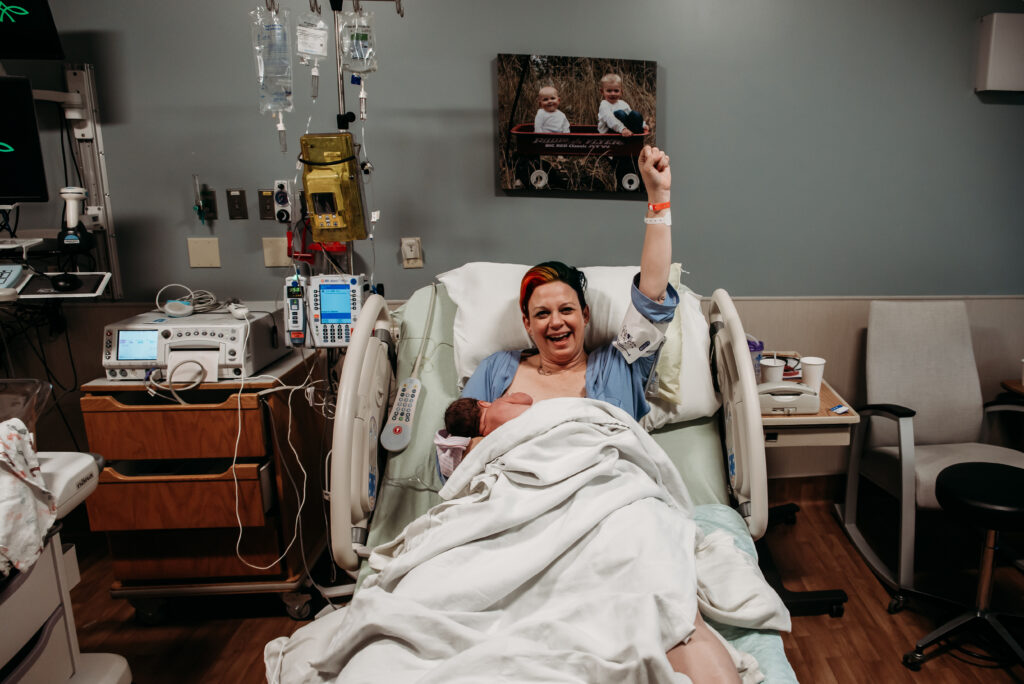 Mom raising her fist in victory after birthing her baby boy at Longmont United Hospital.