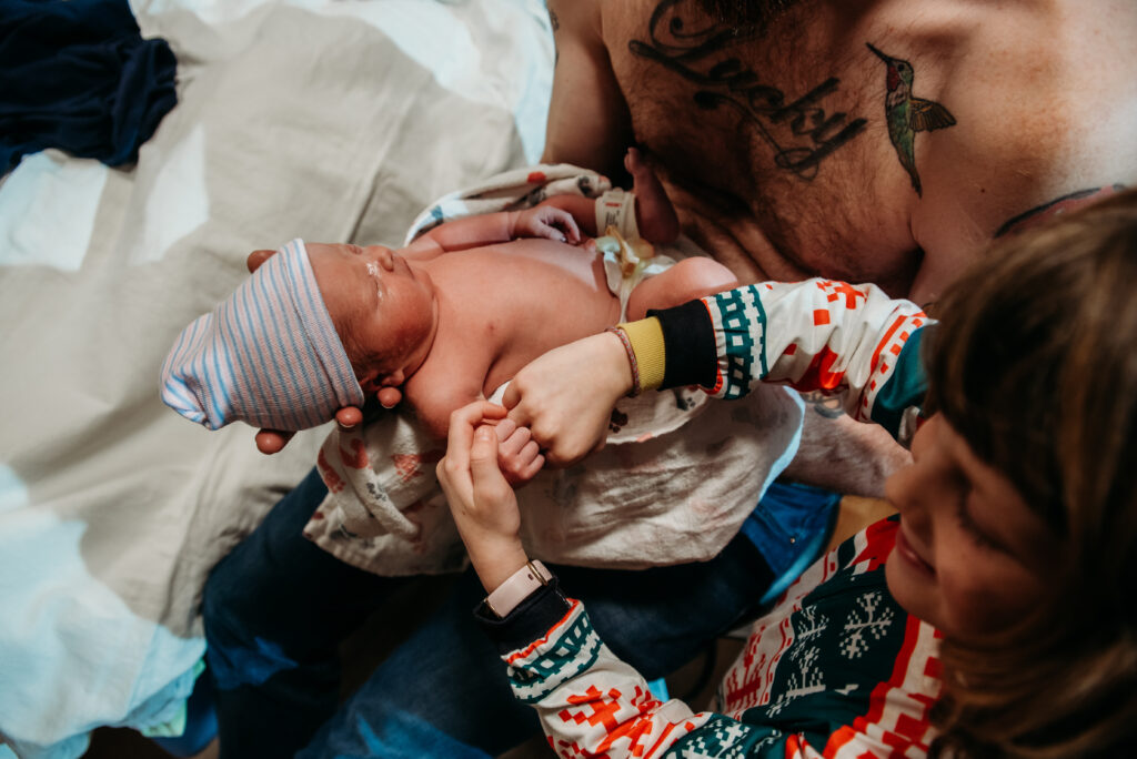 Big sister giving brand new baby brother a fist bump at Longmont United hospital