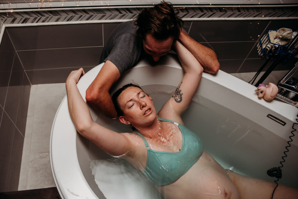 Husband supporting wife while she labors in the tub at Seasons Community Birth Center in CO