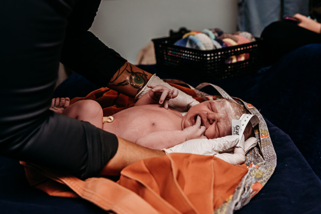 Midwife at Seasons birth center measures the head of a just born baby boy.