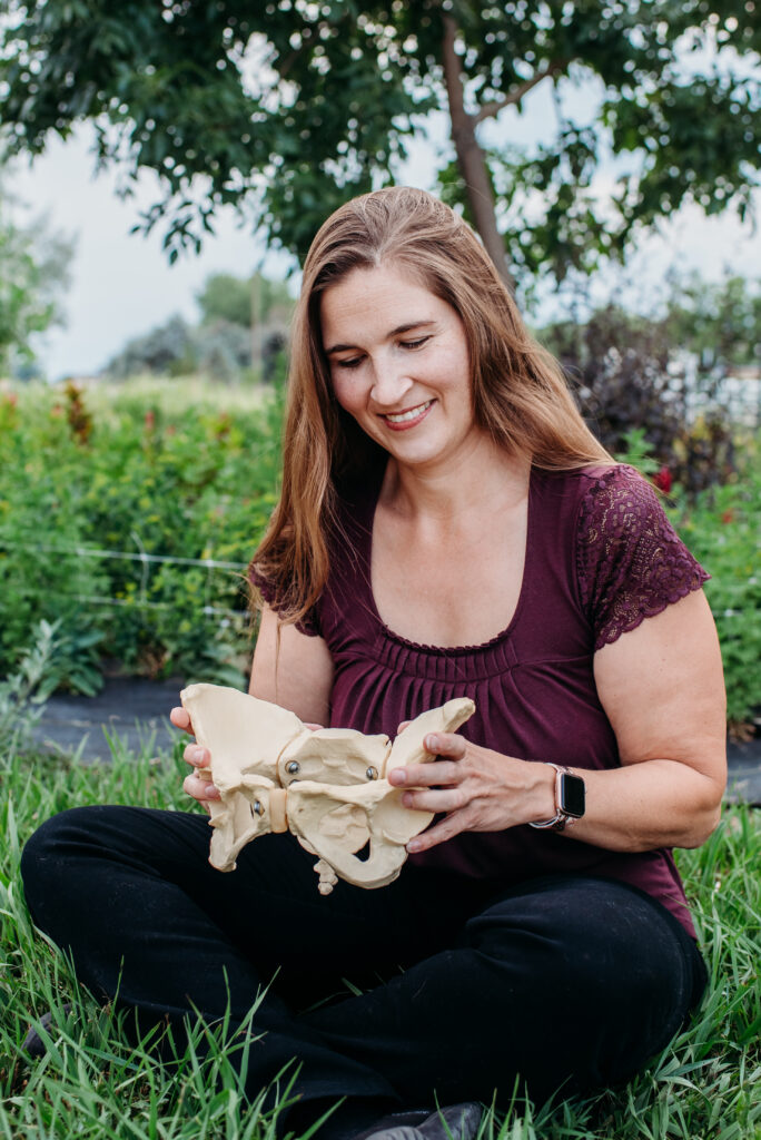 Northern CO home birth midwife sitting with a model of a pelvis in her lap