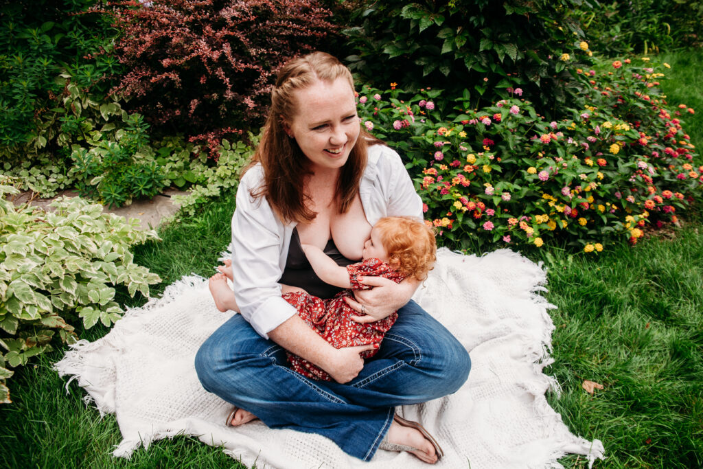 mom and daughter nursing in the flower garden