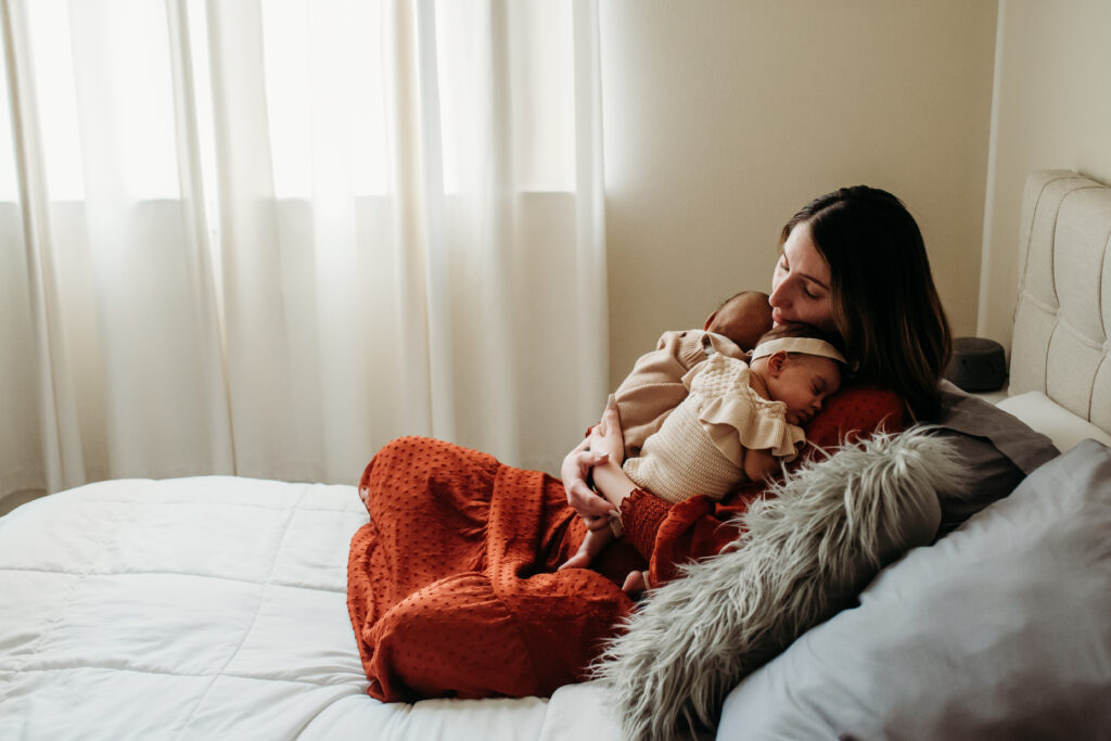 photo of mom with infant twins on bed in her home