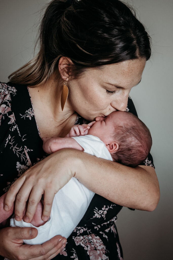 mom kissing baby newborn photo