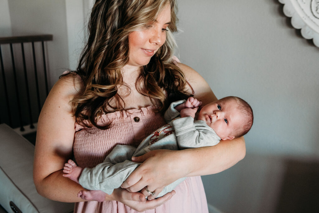 mom in pink holding baby