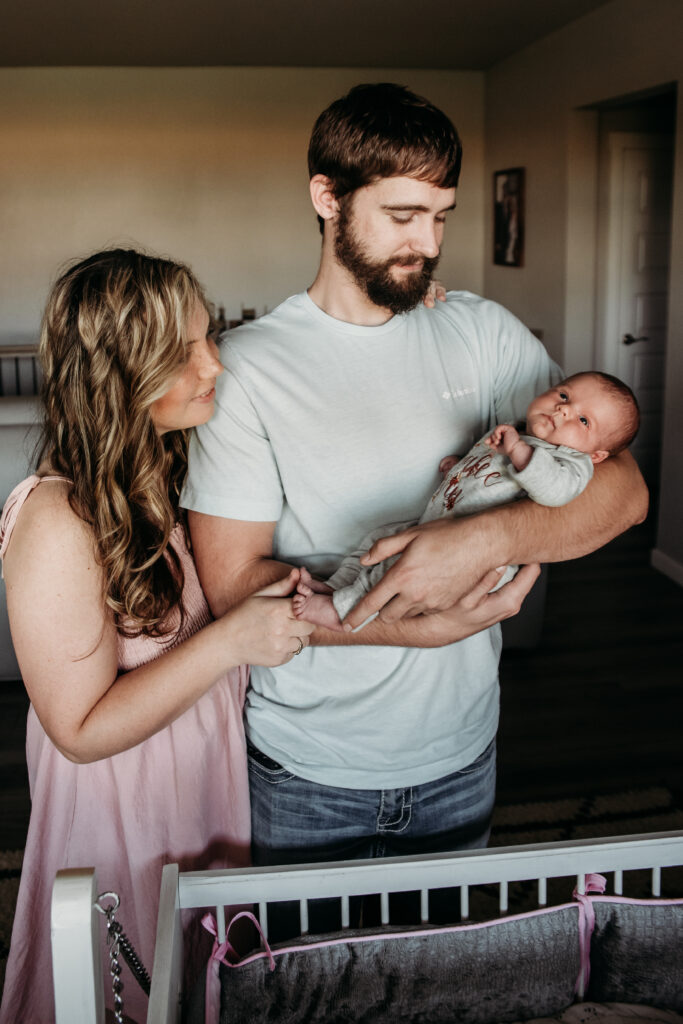 mom and dad admiring baby in their home in Longmont colorado