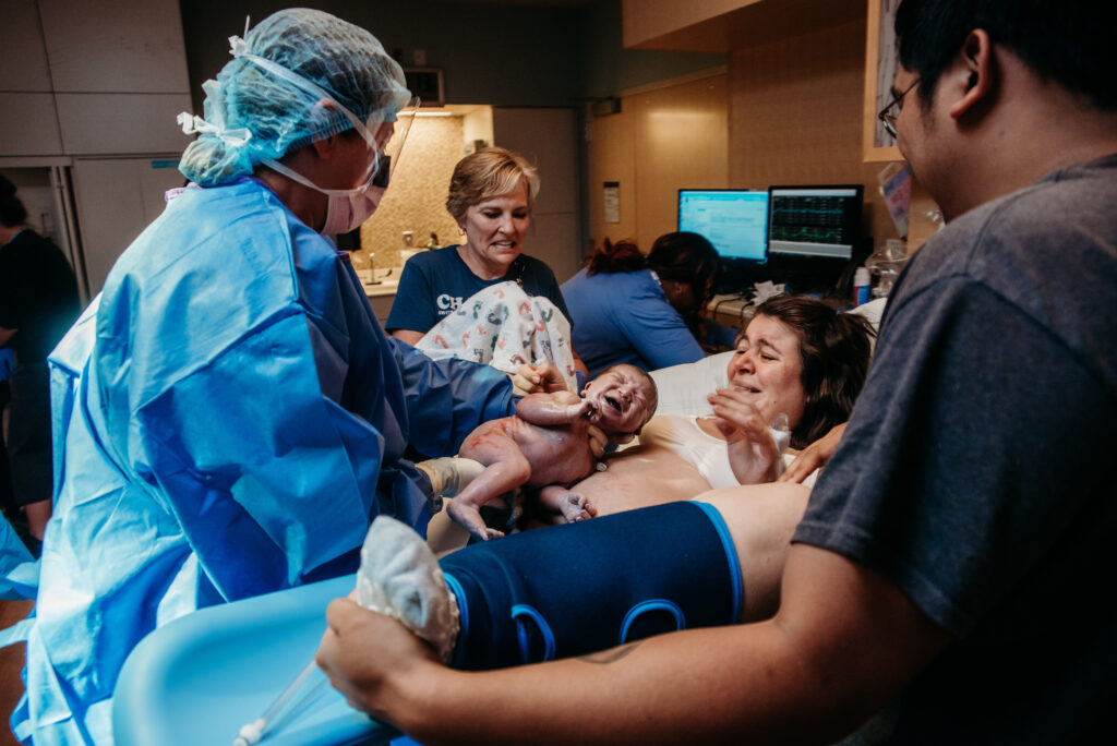 Birth photo of OB putting baby on mom's chest after being born. 