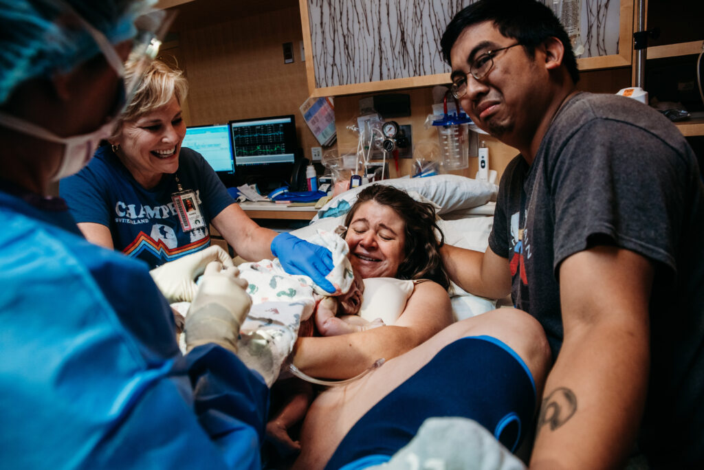 Mom holding freshly birthed baby on her chest. Birth photography at Children's Hospital Anschutz Colorado