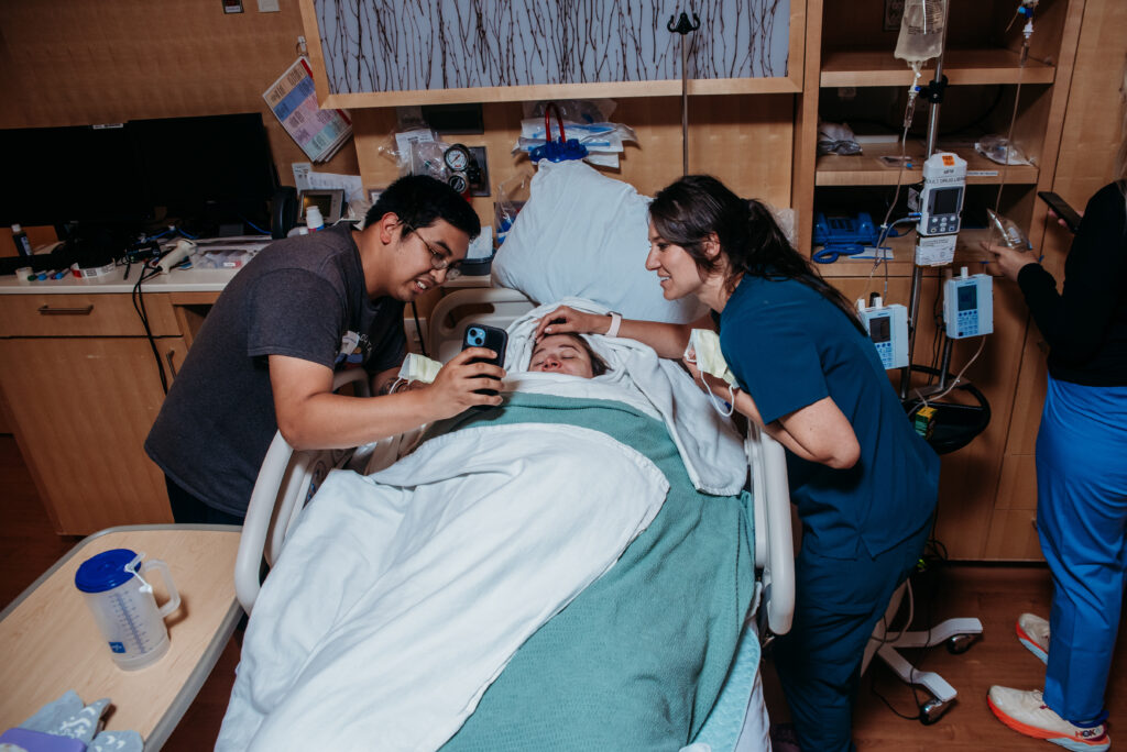 Dad showing mom photos of their new baby that was taken to the NICU