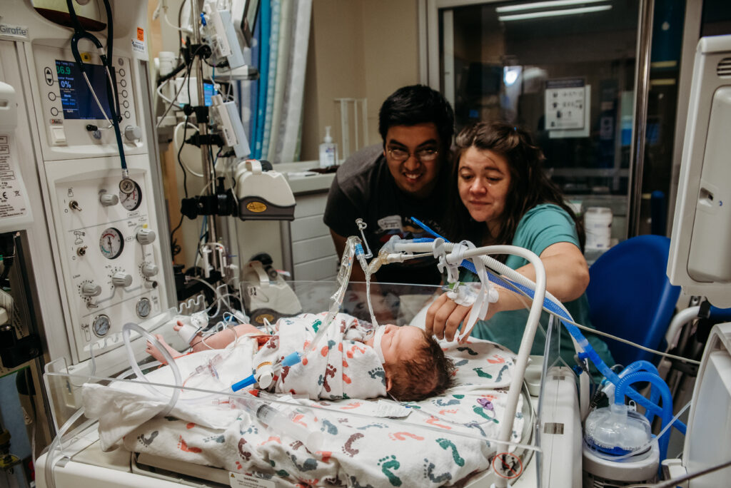 Birth photo of mom and dad in the NICU with their new baby