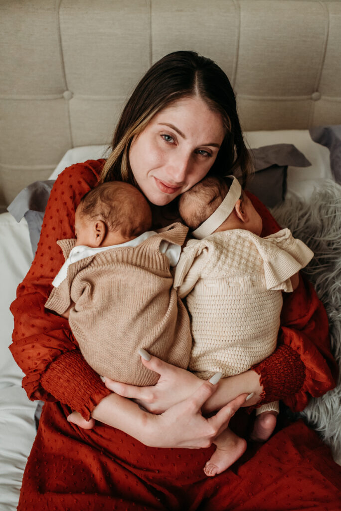 Twins cuddling mom for a photo on the bed