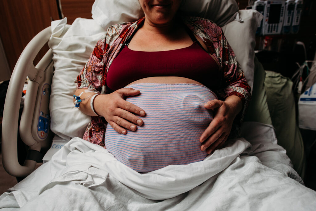 pregnant mama holding her belly in the hospital during labor