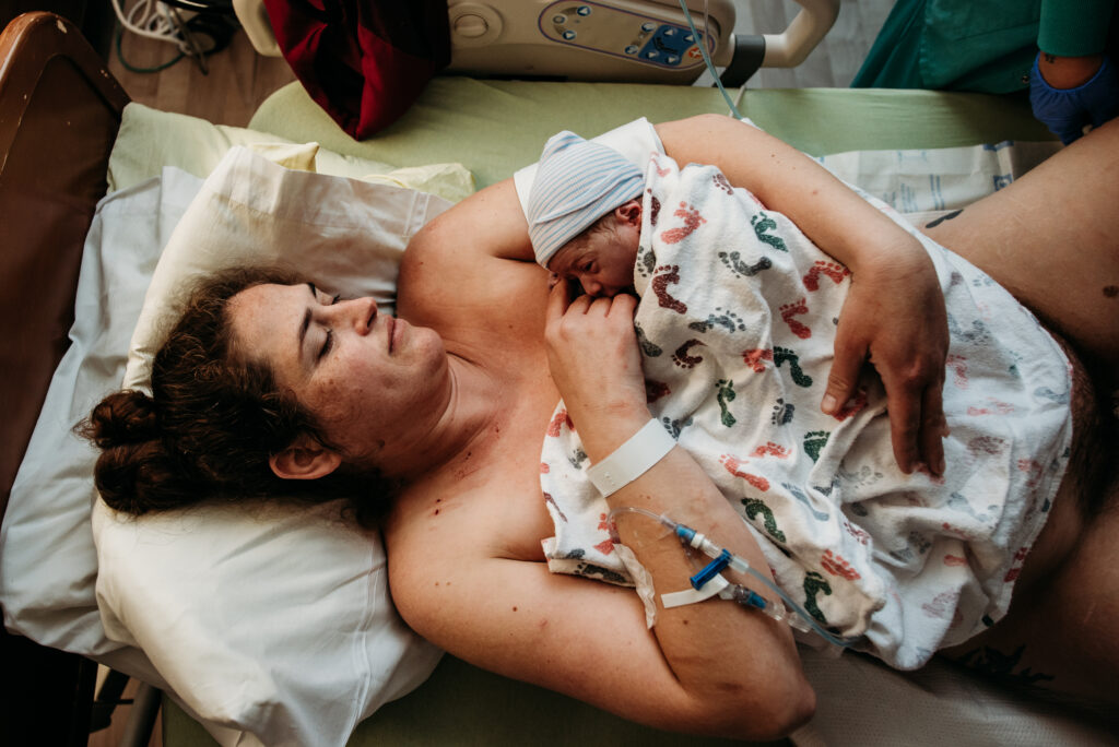 mom holding her rainbow baby in the hospital