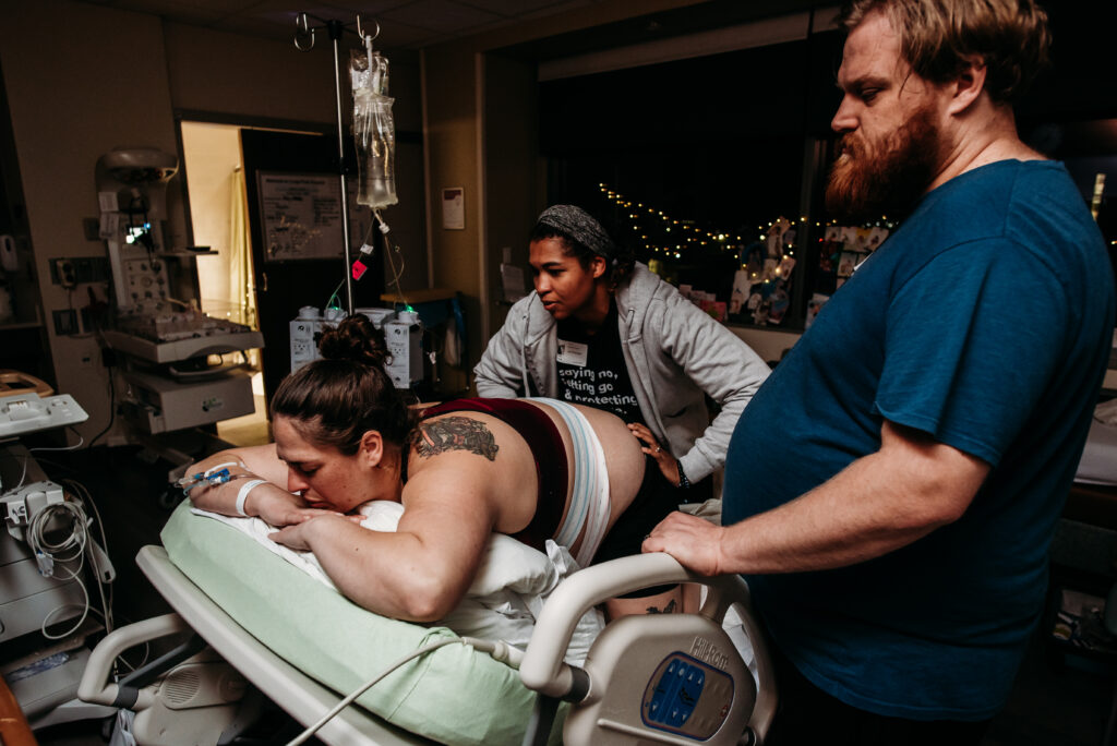 Doula Caitlin Peace supporting laboring mom with hip squeeze
