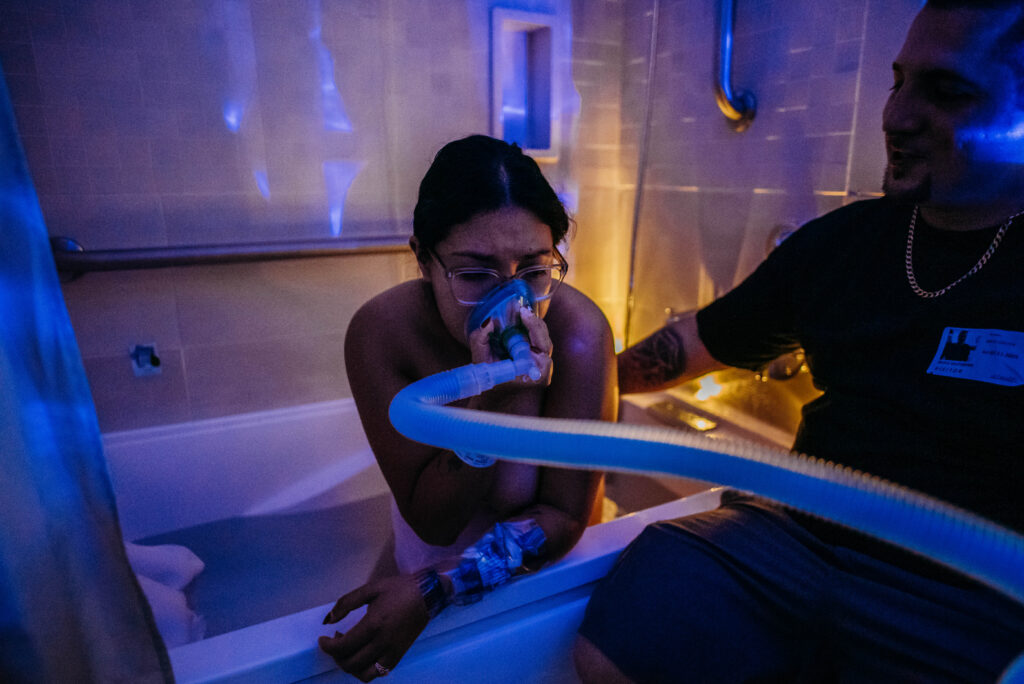 Birth photo of mom in bath using nitrous oxide to help her through contractions with the CU Center for Midwifery in Longmont CO