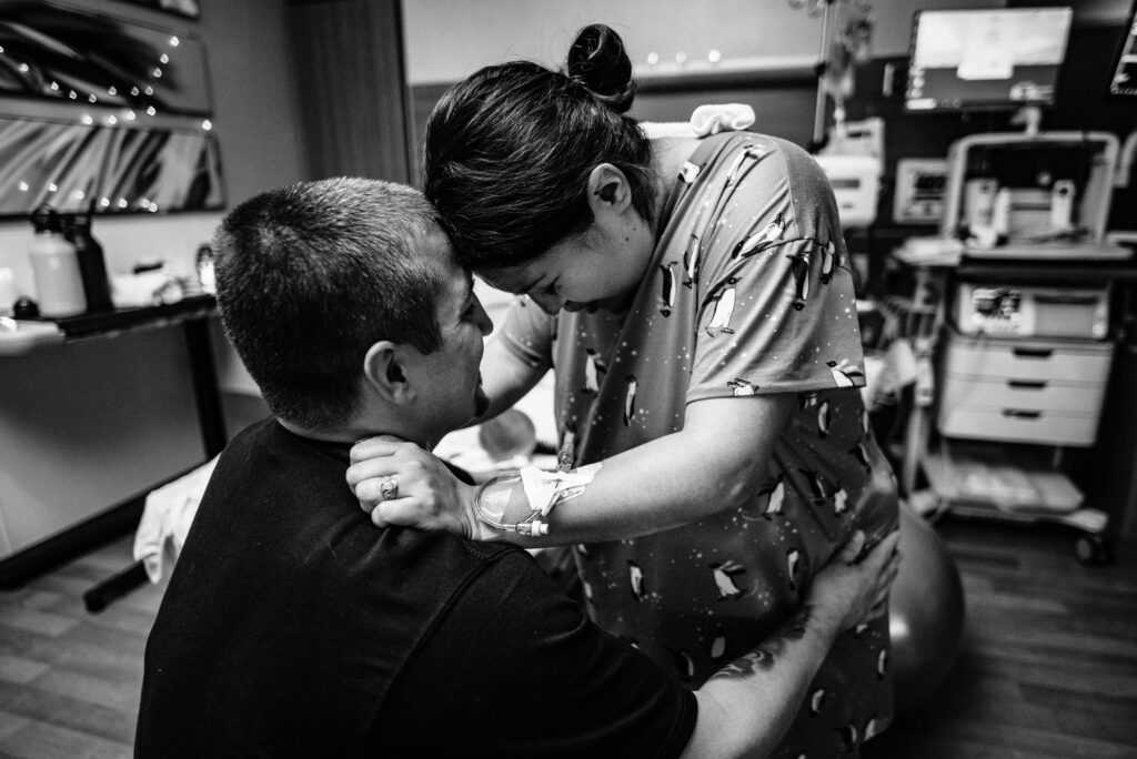 labor photo of mom leaning on dad for support through contractions