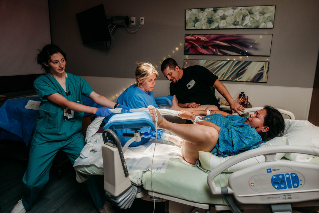 Nurse at Longs Peak hospital doing tug of war with mom to help push baby out during labor and birth 