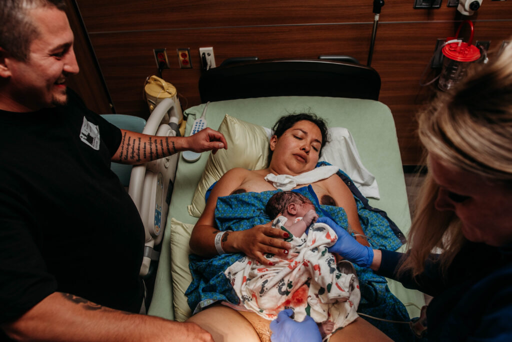 Birth photo of the first time mom gets to hold her baby girl after birth.