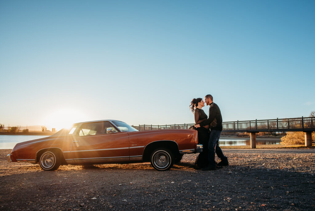 Pregnant couple posing with old car by lake. Maternity photo inspiration Mead CO