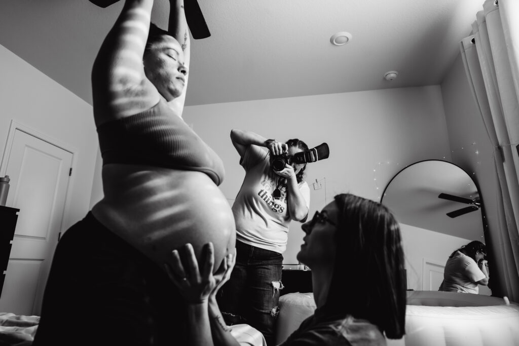 birth photographer working with laboring mom and doula